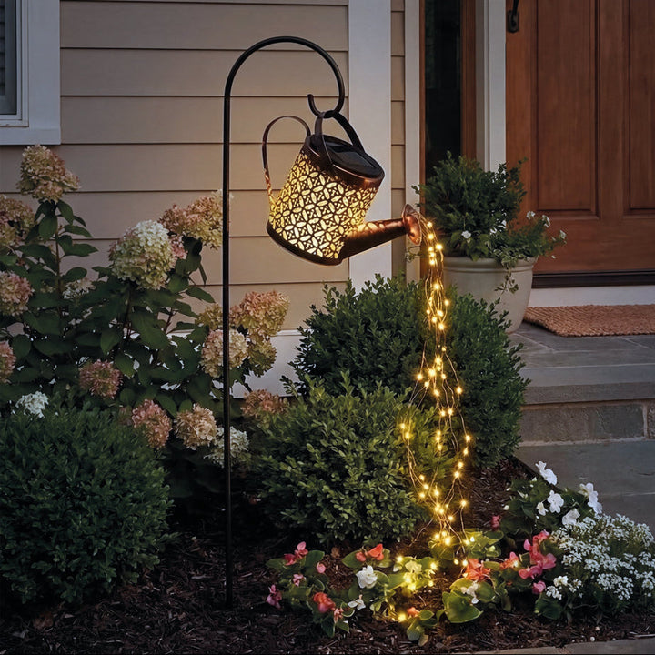 Regadera decorativa con luz solar para jardín, creando un efecto de cascada luminoso y energía solar.