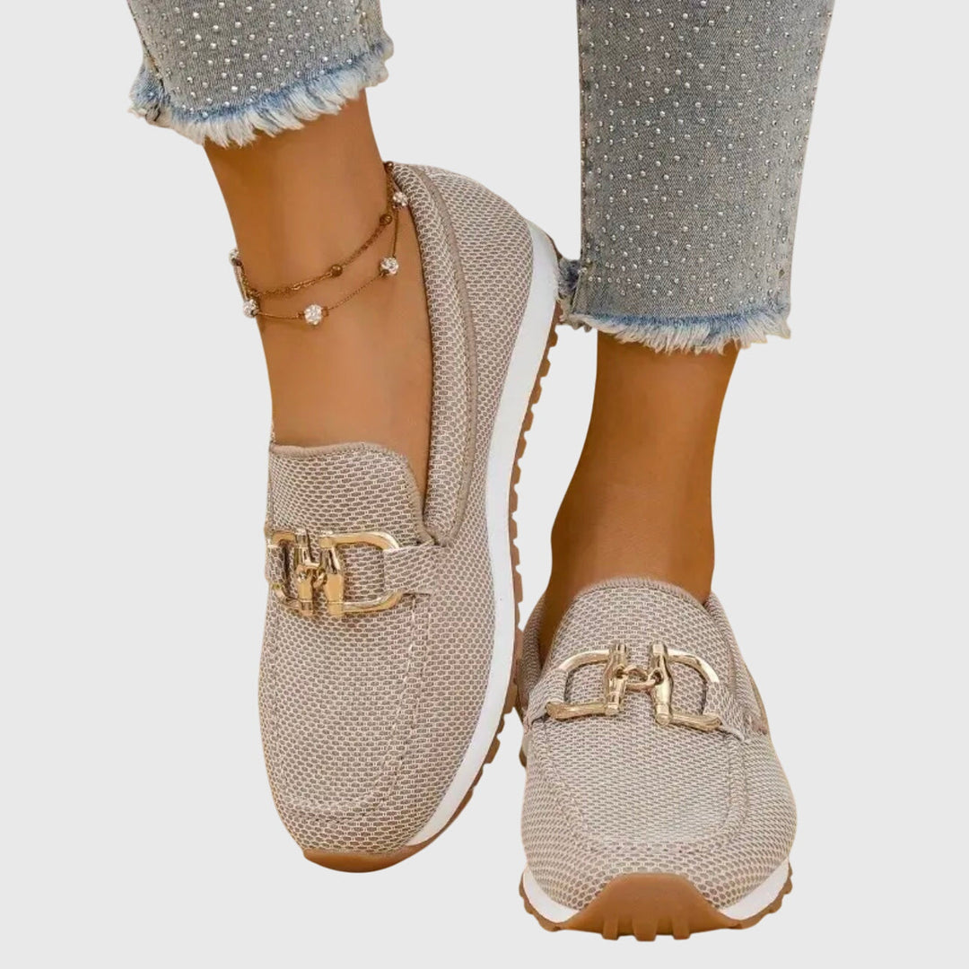 Mocasín de mujer en malla transpirable color neutro con hebilla dorada, calzado cómodo y versátil.
