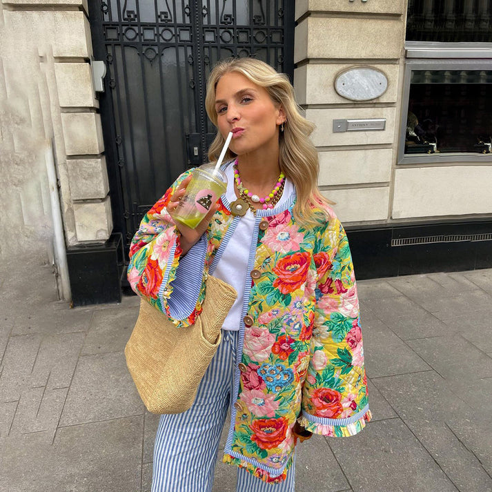 Cálido abrigo de mujer con patrón floral vibrante y botones decorativos. Prenda de moda para el frío.
