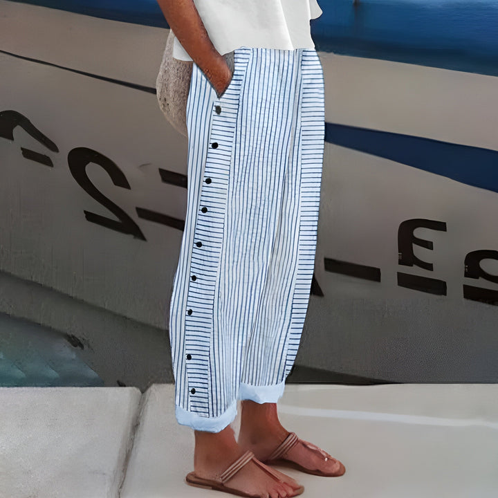 Detalle de los botones en el pantalón rayado de mujer, estilo casual.