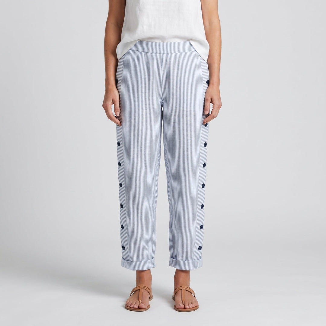 Pantalón de mujer con rayas verticales y botones decorativos, look casual.