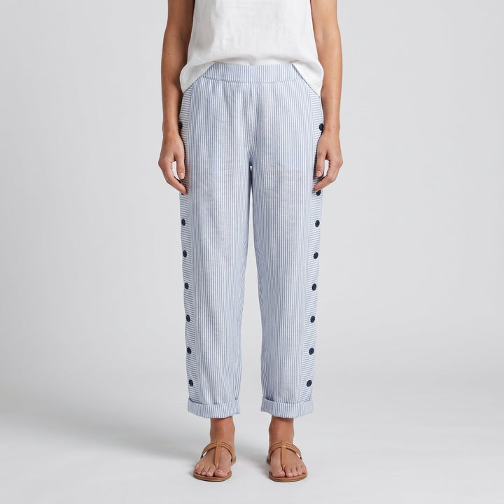 Pantalón de mujer con rayas verticales y botones decorativos, look casual.