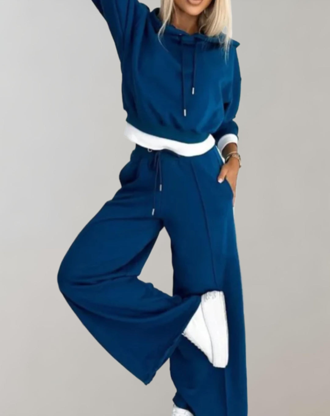 Modelo luciendo conjunto de sudadera corta y pantalón ancho. Moda urbana femenina, cómodo y a la moda.