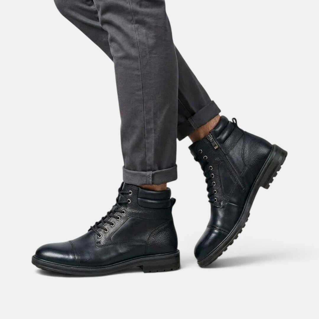 Primer plano de botines masculinos workwear. Textura de material duradero y doble cierre visible.