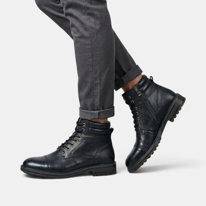 Primer plano de botines masculinos workwear. Textura de material duradero y doble cierre visible.