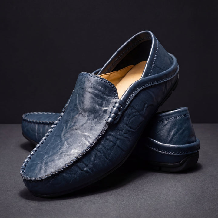 Hombre usando mocasines de piel azul marino, ideales para un look casual y cómodo. Calzado de verano.