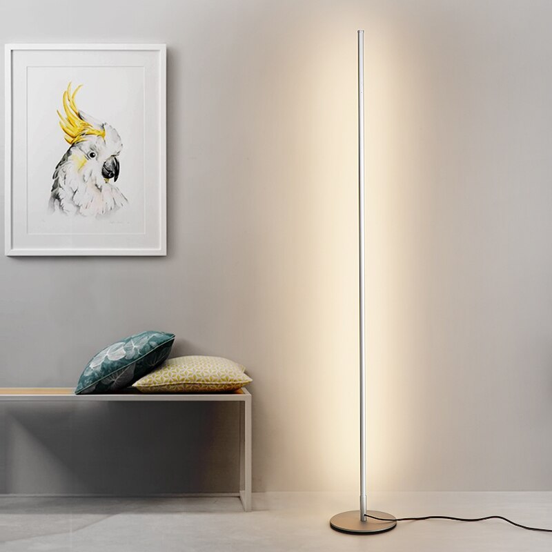 Lámpara de pie LED de diseño minimalista con base circular, ideal para iluminación moderna en dormitorio o sala.