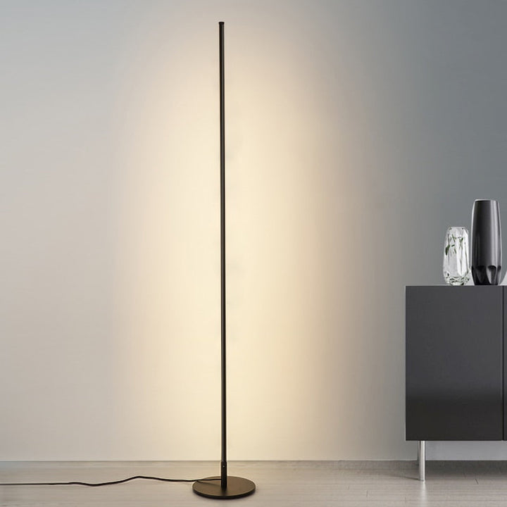 Lámpara de pie LED con tubo delgado, base circular y luz regulable. Diseño minimalista para iluminación moderna.
