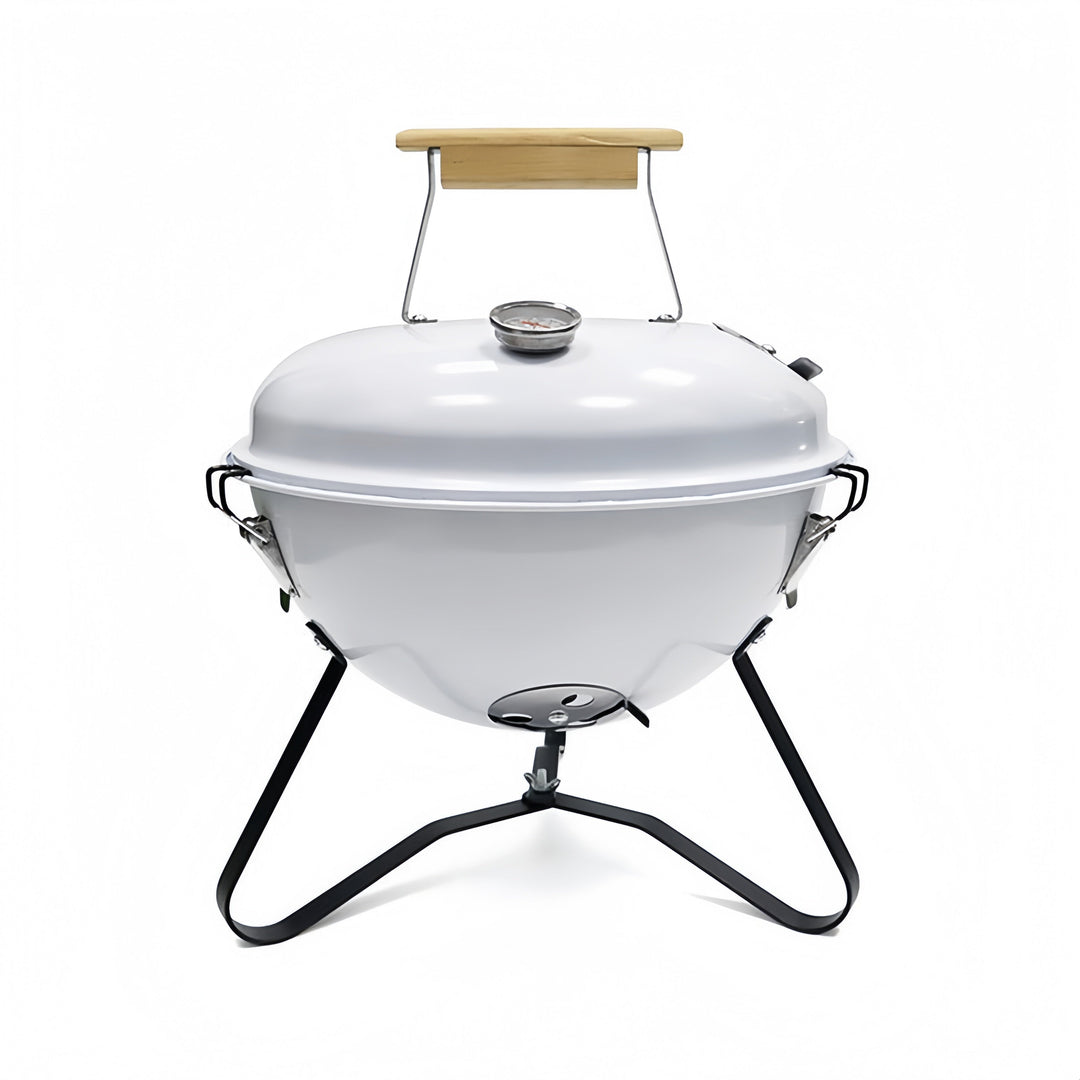 Grill de carbón con tapa y patas estables para seguridad en el exterior.