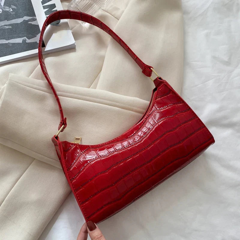 Cartera de mujer de piel de cocodrilo brillante, accesorio de moda chic.