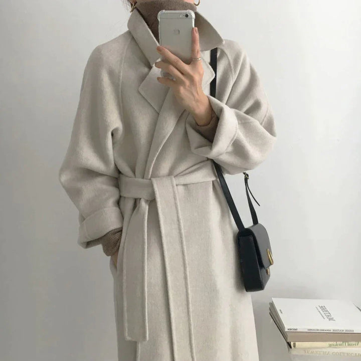 Detalle de abrigo de mujer cálido, ideal para invierno. Diseño largo y sofisticado para ropa de moda femenina.