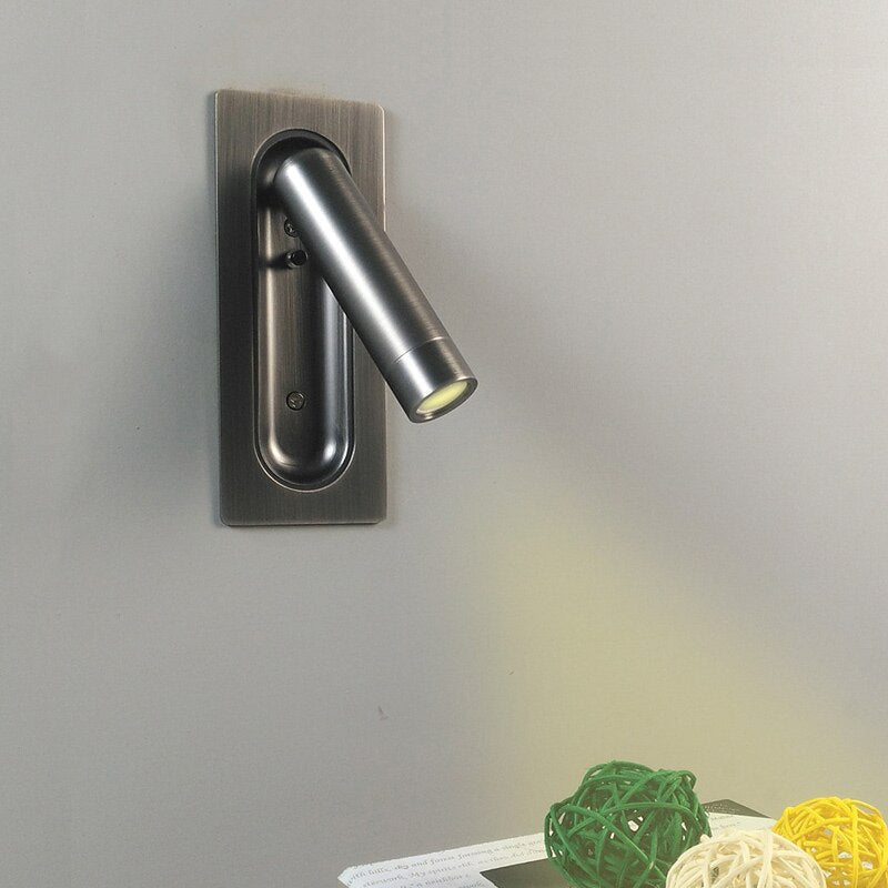 Aplique de pared LED de luz cálida, ideal para lectura nocturna en cabecera de cama.