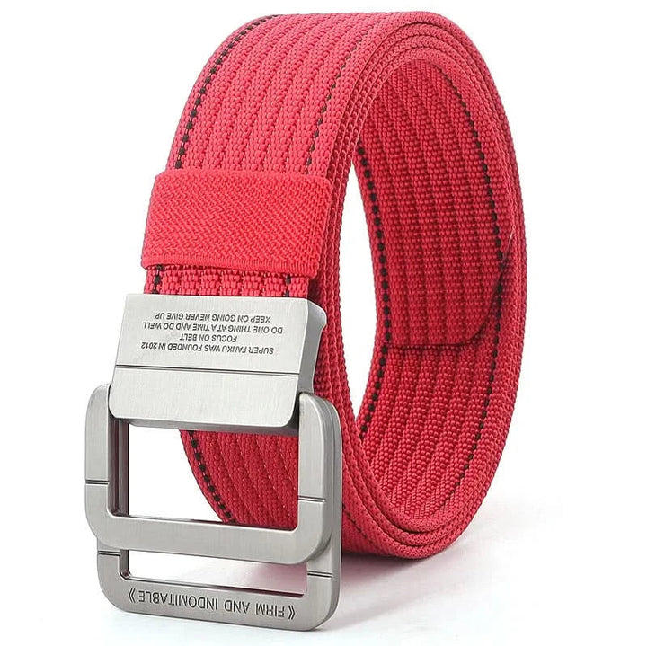 Detalle de hebilla doble anilla metálica en cinturón de lona gris unisex, un accesorio moderno.