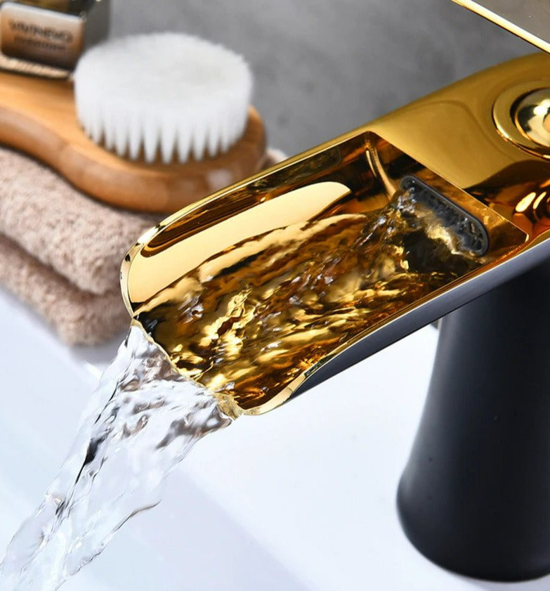 Sofisticado grifo de lavabo cascada, diseño contemporáneo en metal pulido y brillante.