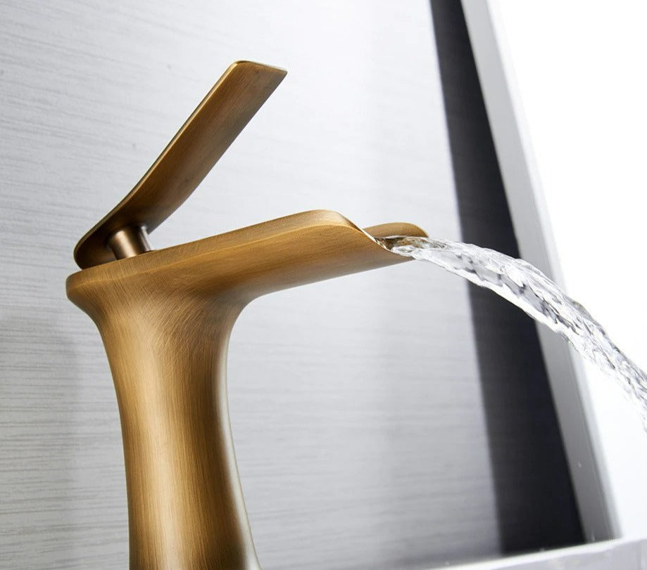 Elegante grifo de baño cascada en metal, diseño moderno, aporta sofisticación al espacio.