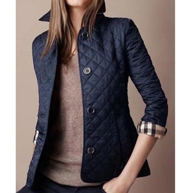 Detalle de la textura acolchada de la chaqueta de mujer, destacando su calidad y diseño moderno.
