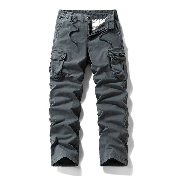 Hombre mostrando pantalones cargo tácticos. Ajuste cómodo y diseño moderno para la moda masculina activa.