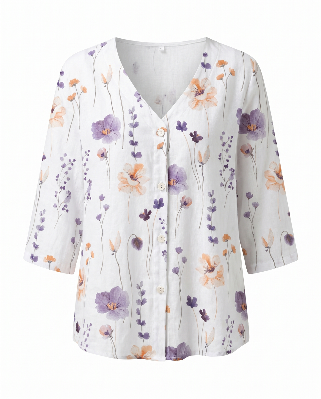 Primer plano de blusa blanca con bordado floral detallado, cuello V, tejido suave.