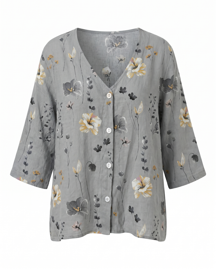 Mujer vistiendo blusa floral bordada de cuello V, ajuste relajado. Moda casual de verano.