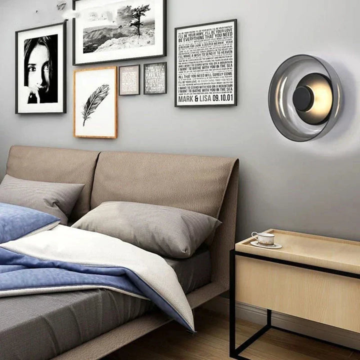 Lámpara de pared con diseño moderno y pantalla de vidrio esférica, aportando luz cálida a cualquier interior.