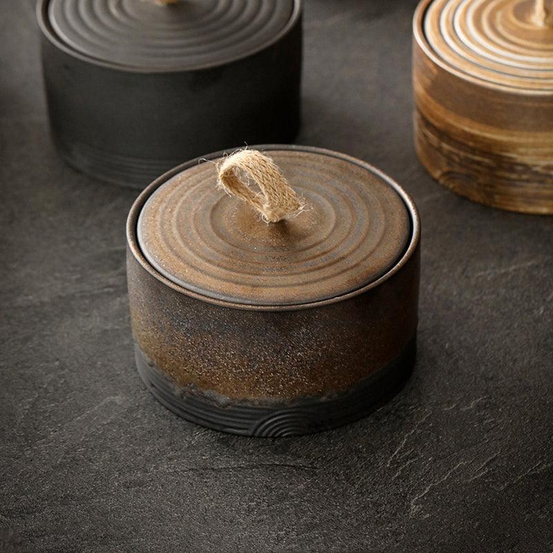 Frasco de cerámica japonés estilo wabi-sabi con cuerda de cáñamo, ideal para almacenamiento y decoración artesanal.