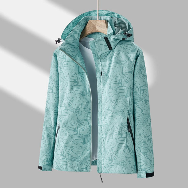 Mujer en el exterior con chaqueta cortavientos impermeable y capucha. Protección ligera para deporte, senderismo o casual.