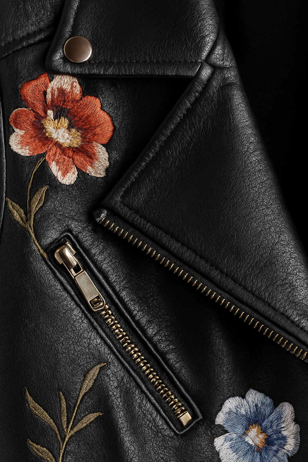 Textura de polipiel en chaqueta negra de mujer, con bordado floral. Ideal para otoño e invierno.