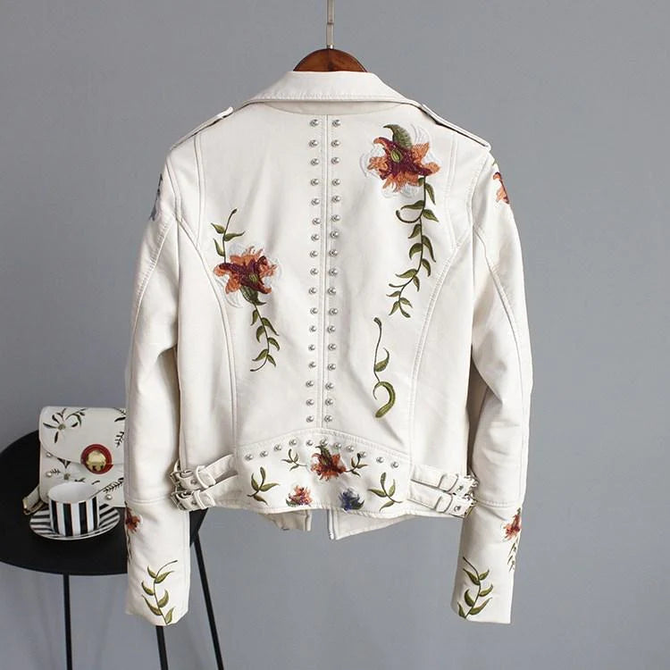 Modelo luciendo chaqueta de polipiel negra con bordado floral. Un look biker elegante y de tendencia.