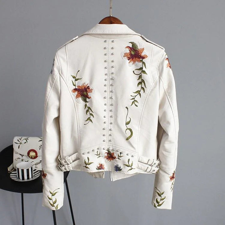 Modelo luciendo chaqueta de polipiel negra con bordado floral. Un look biker elegante y de tendencia.