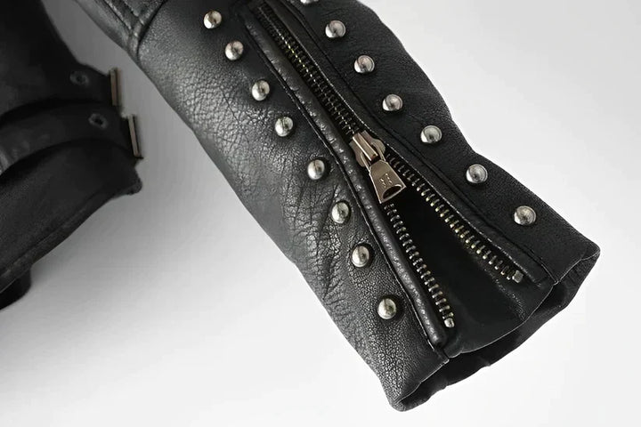 Primer plano del cuello y cremallera de chaqueta de polipiel para mujer, con sutiles detalles de bordado floral.