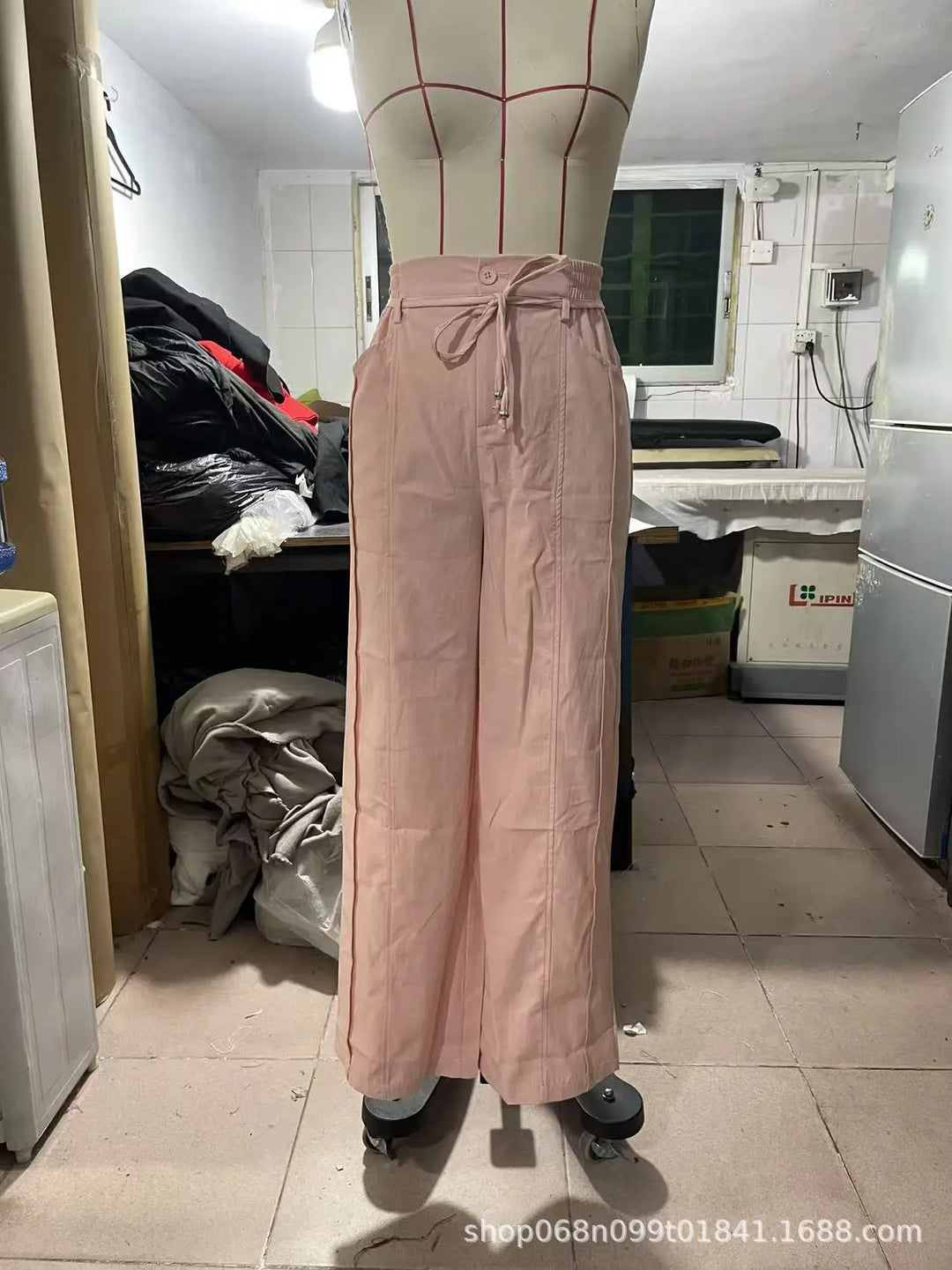 Mujer con pantalones tiro alto y pierna ancha en tono pastel, estilo casual-elegante y relajado.