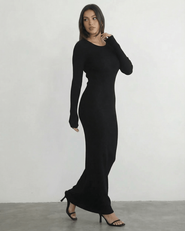 Mujer luciendo vestido maxi negro de manga larga con elegante espalda abierta. Ropa de fiesta.