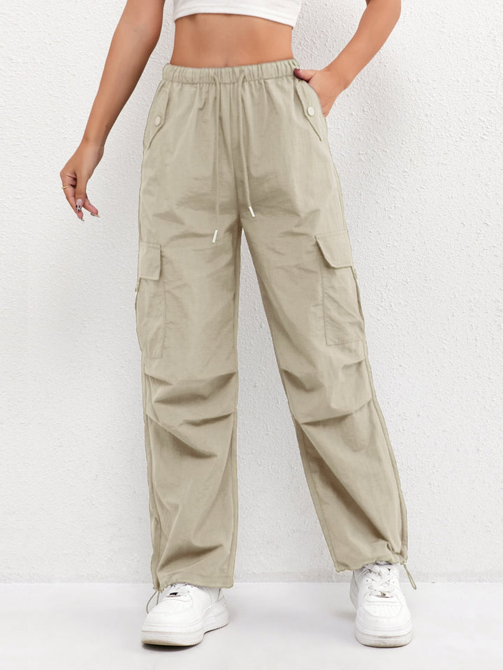 Mujer luciendo pantalón cargo tiro alto, cintura elástica con bolsillos grandes. Atuendo casual y cómodo.