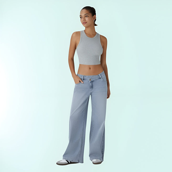 Pantalones vaqueros asimétricos tiro bajo de mujer, elásticos. Moda cómoda azul denim casual.