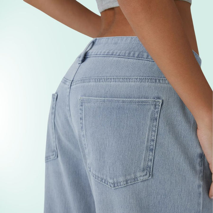 Comodidad en vaqueros elásticos mujer, tiro bajo asimétrico. Estilo casual en azul denim.