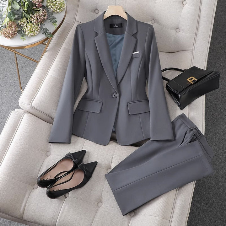 Traje formal de dos piezas para mujer, incluye blazer y pantalón de vestir gris. Perfecto para moda ejecutiva.