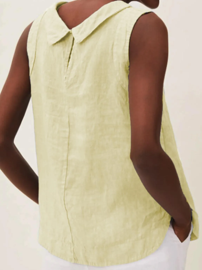 Mujer usando blusa de lino manga corta. Disfrutando la frescura del verano con estilo casual.