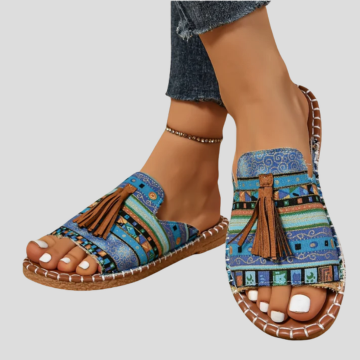 Elegantes sandalias de mujer con borlas, diseño abierto. Suela artesanal cosida para comodidad y estilo de verano.