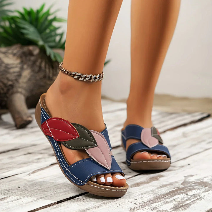 Vista lateral de sandalias florales de mujer, combinan confort y elegancia para el día a día.