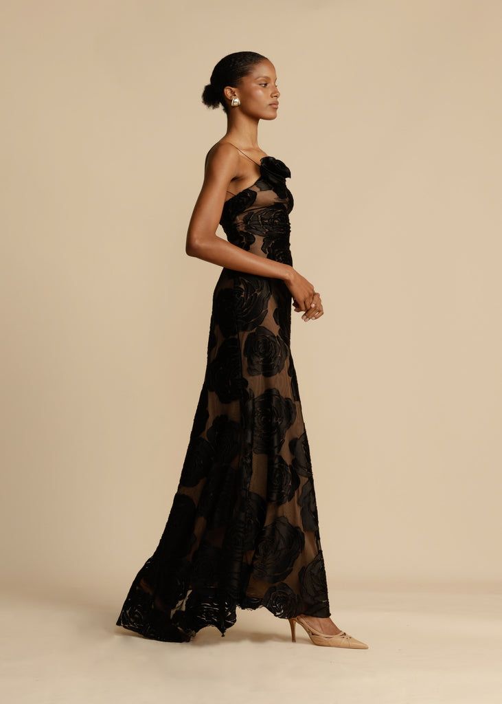 Mujer luciendo un vestido largo de noche con volantes, elegante y de diseño exclusivo. Ideal para fiesta y gala.