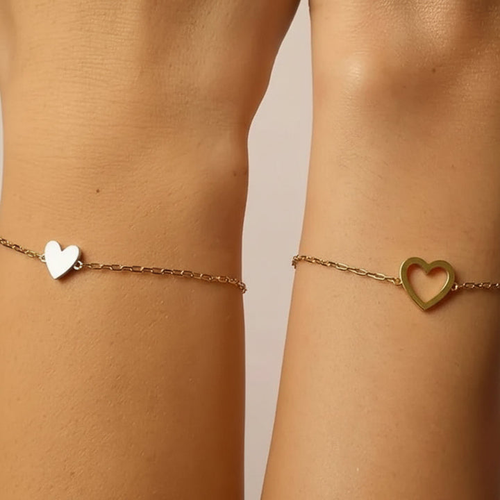 Primer plano de la pulsera de cadena de corazón ajustable. Joyería minimalista unisex en dorado/plateado para parejas.