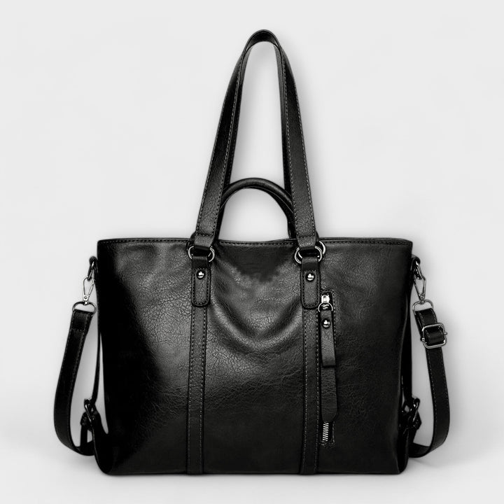 Bolso tote mujer negro de piel sintética con asas, estilo chic y bandolera. Complemento ideal para outfit casual.