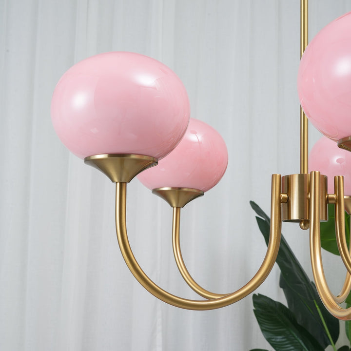 Araña Alora Marshmallow, combinando arte y luz con cristal rosa y estructura dorada.