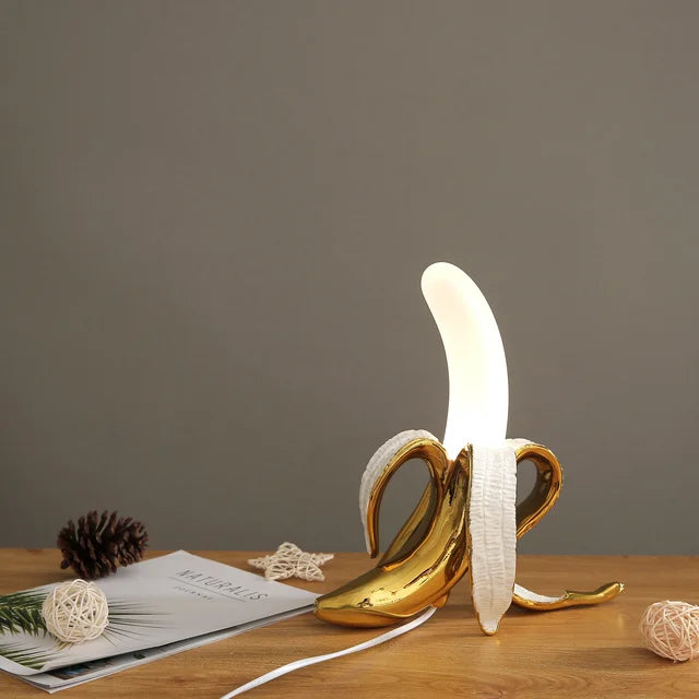 Lámpara de mesa moderna con forma de plátano. Diseño creativo para decoración de hogar y estilo único.
