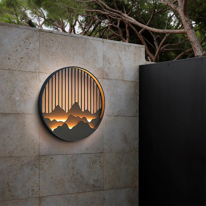 Aplique LED circular IP65, motivo montaña, ideal para luz decorativa en hogar o jardín.