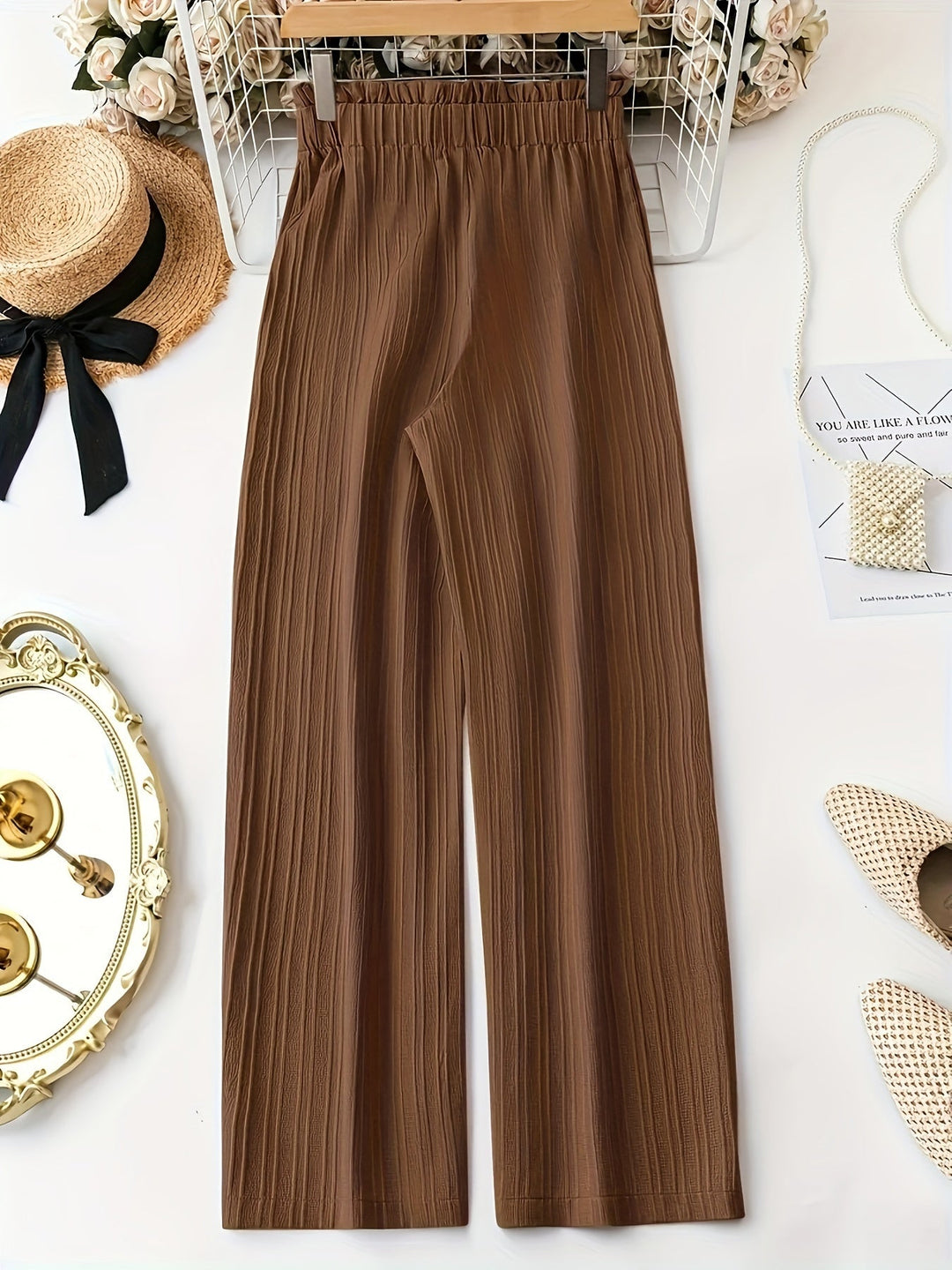 Pantalones elegantes de mujer, plisados color caramelo. Diseño de talle alto y pierna ancha para comodidad.