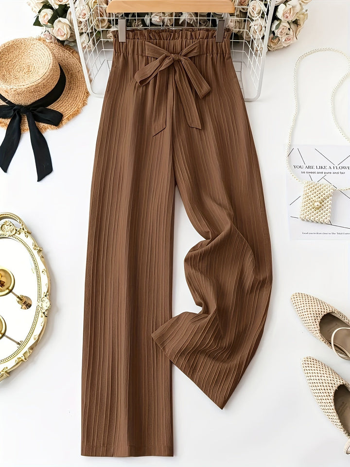 Pantalones de mujer plisados color caramelo, de talle alto y pierna ancha. Estilo elegante y cómodo.