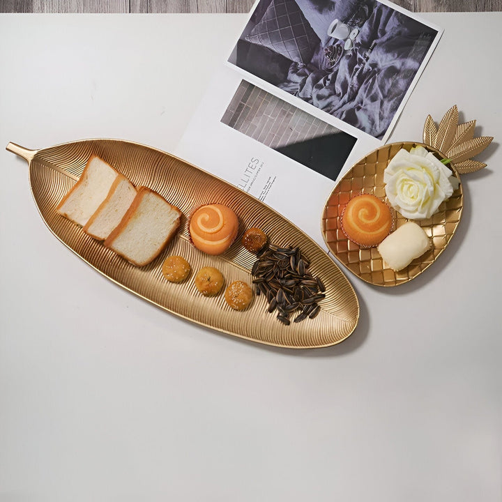 Sofisticada bandeja de madera con detalles dorados y silueta de hoja tropical. Objeto de decoración y uso.