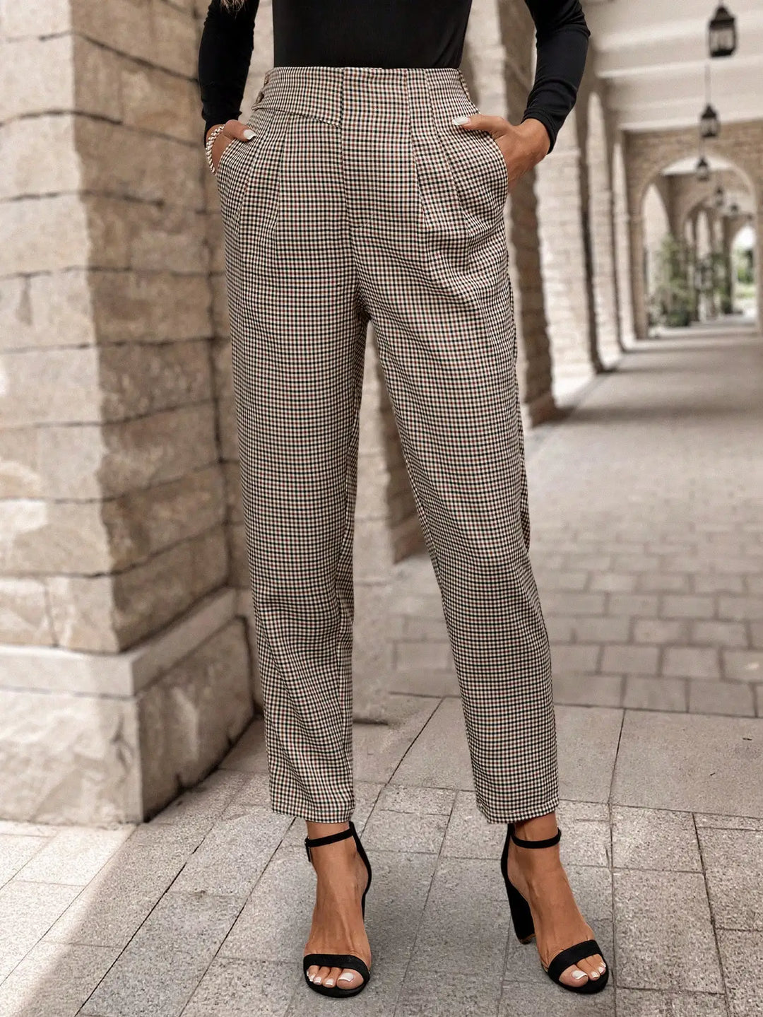 Modelo usando pantalones de mujer a cuadros marrones de tiro alto, look casual-elegante de moda para primavera.