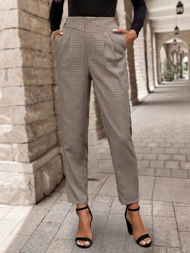 Modelo usando pantalones de mujer a cuadros marrones de tiro alto, look casual-elegante de moda para primavera.
